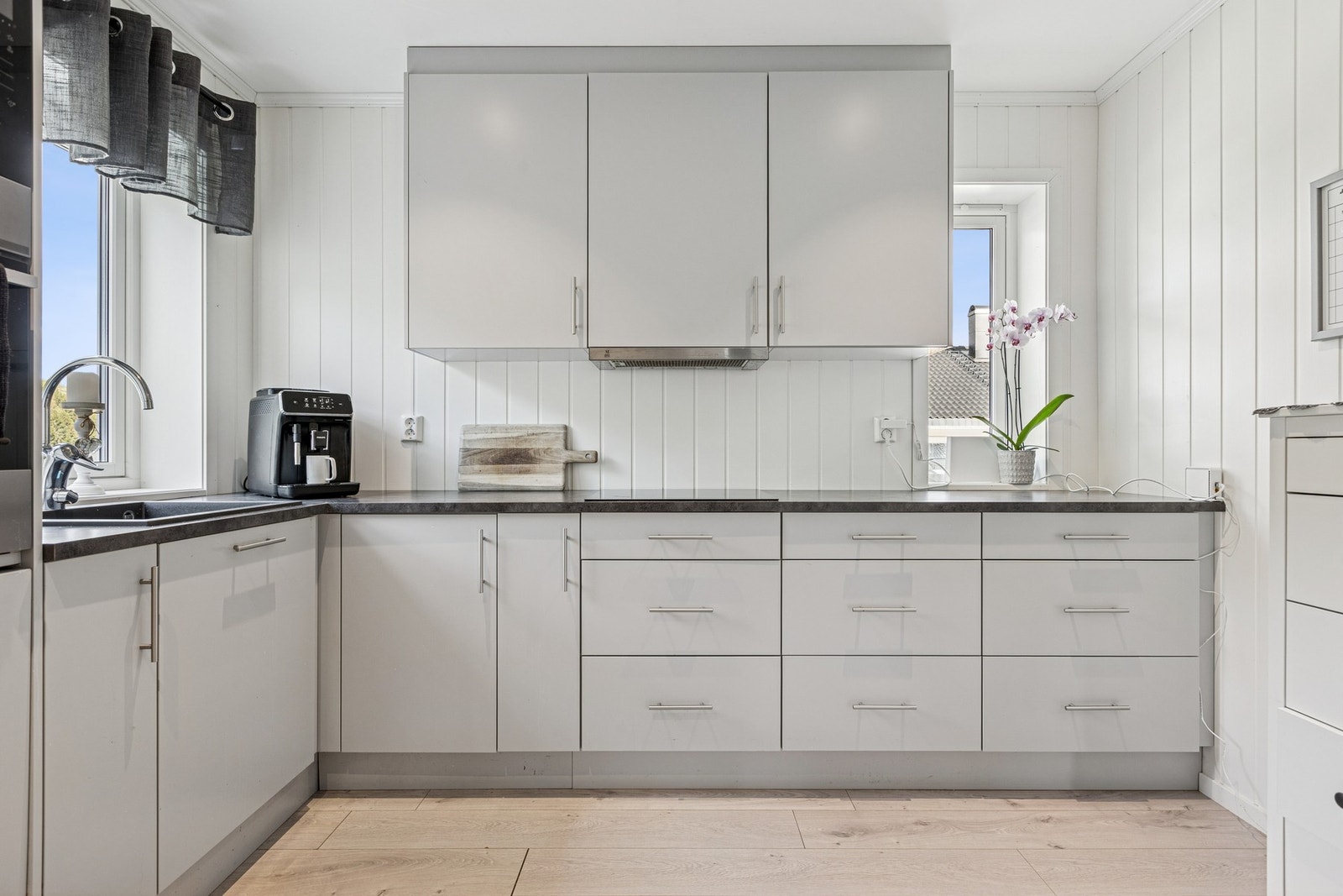 Her får du et moderne og stilrent kjøkken med god skap- og benkeplass og smarte løsninger som gjør både matlaging og hverdagslogistikk enkel og effektiv. Galleribilde