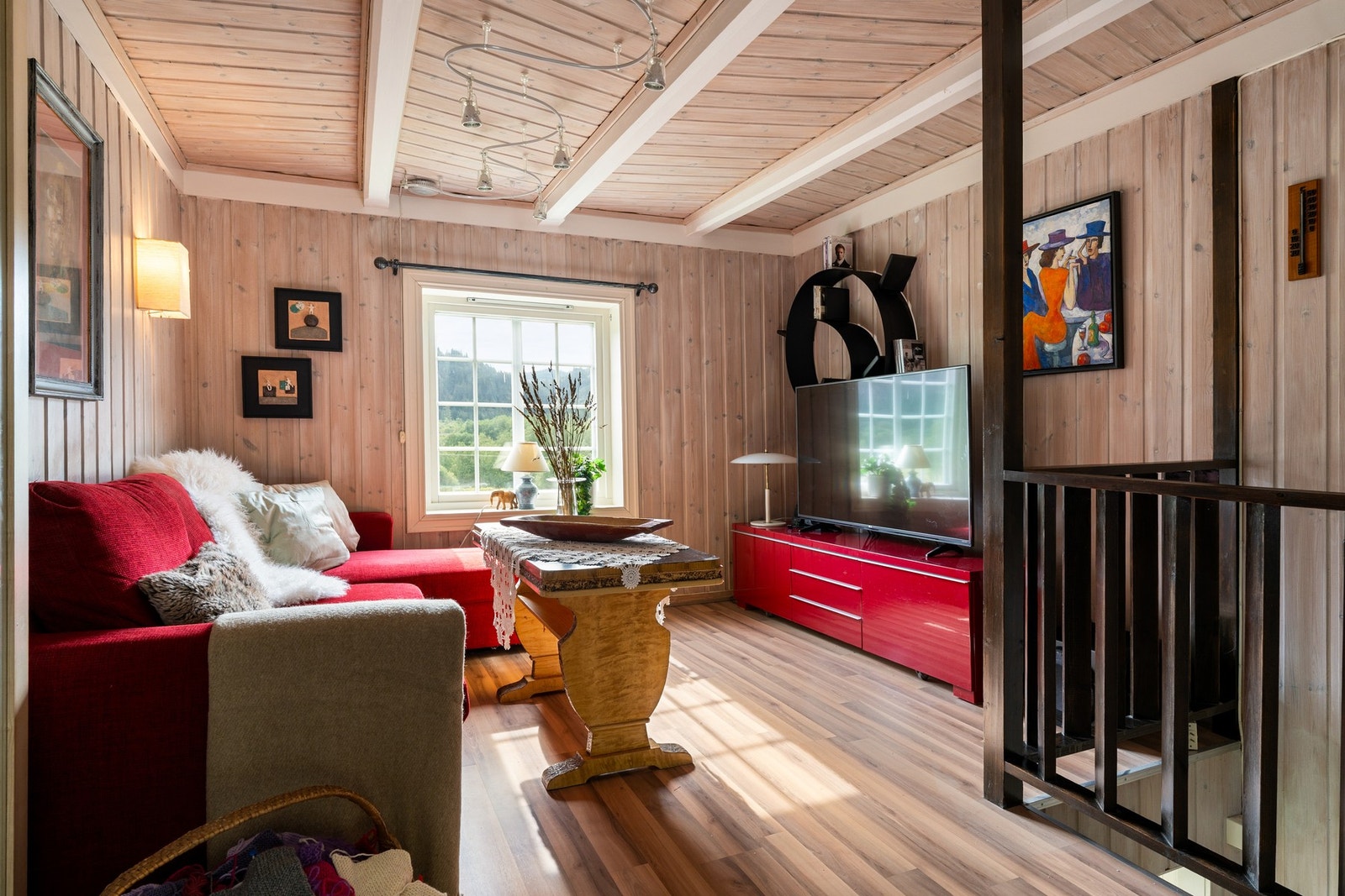 Rett opp fra trappa finner du TV-stua som har hvitkalket panel på veggene. Galleribilde