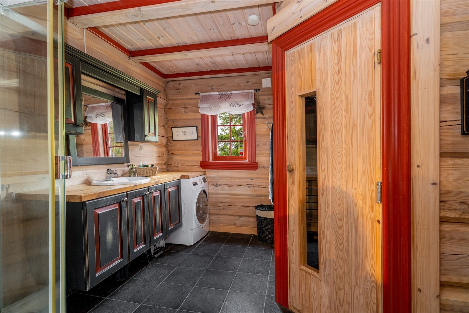 I forlengelse av benkeplata har vaskemaskinen fått sin naturlige plass. Tilliggende badet er det etablert badstue hvor man kan senke skuldrene etter en aktiv dag. Galleribilde