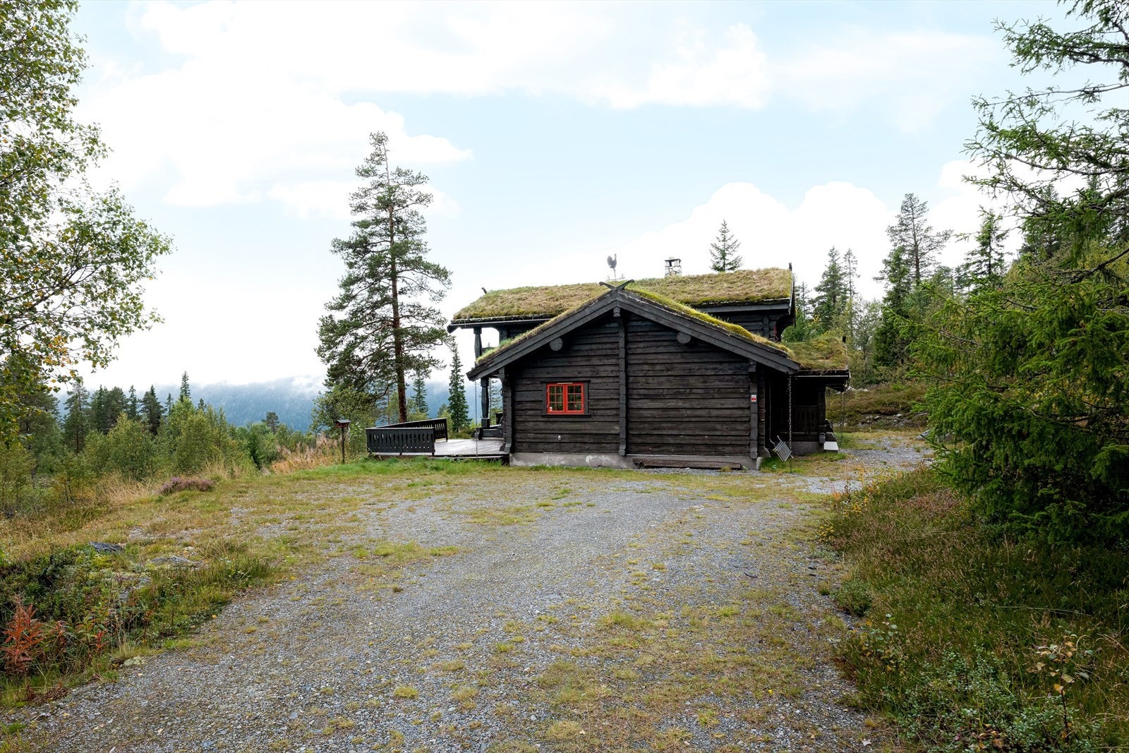Stor gårdsplass med mange biloppstillingsplasser, og ladeboks til el-bil. Galleribilde