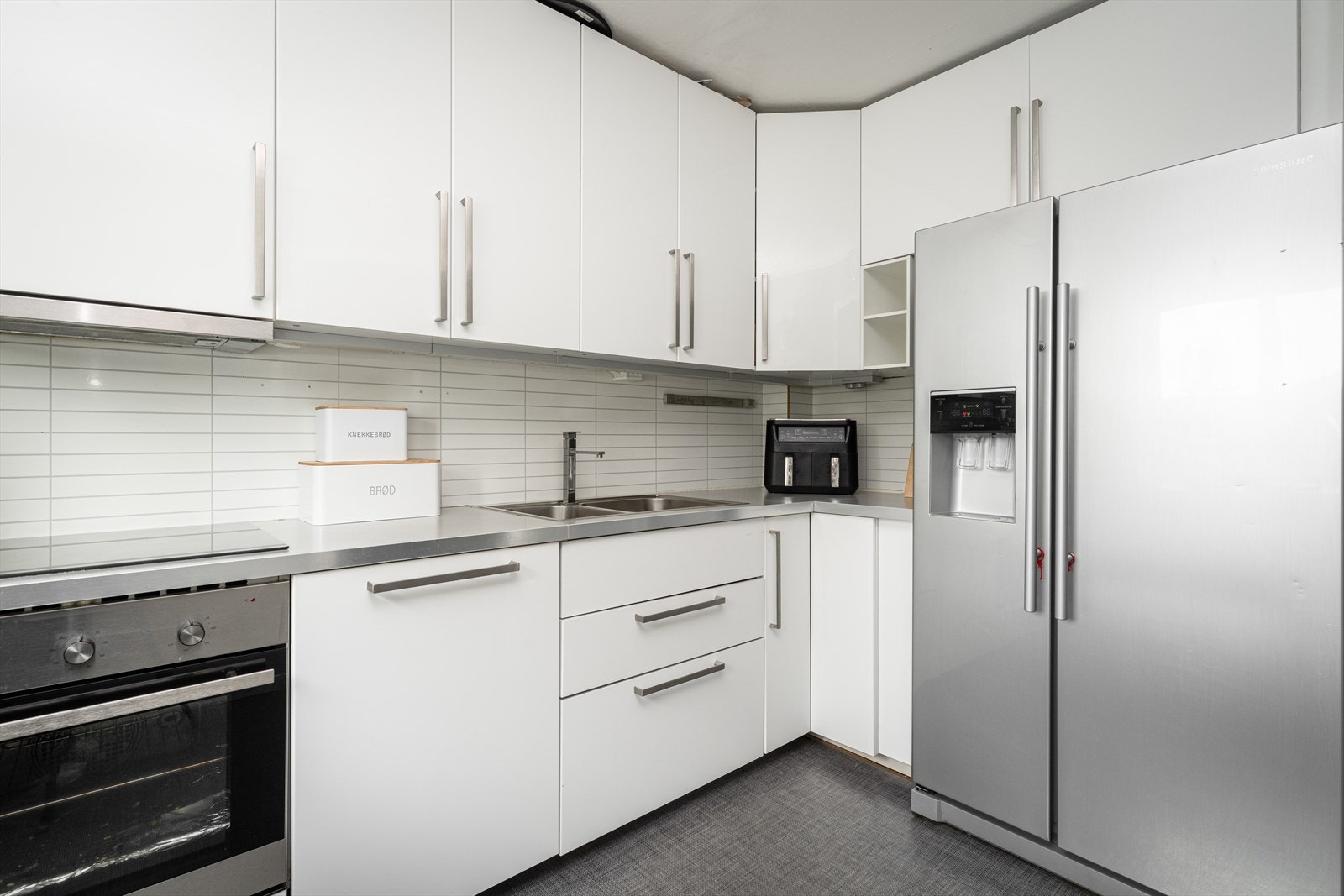 Lyst og pent kjøkken fra 2017 med slette fronter og laminert benkeplate med nedfelt vask. Galleribilde