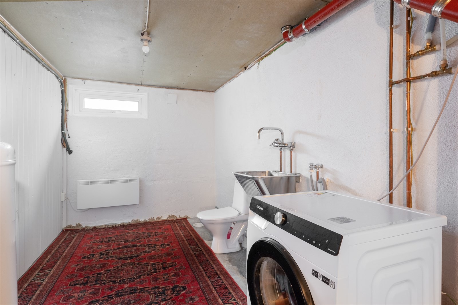 Praktisk vaskerom i kjeller med opplegg til vaskemaskin, utslagsvask, toalett og varmtvannstank på ca. 200 liter. Galleribilde