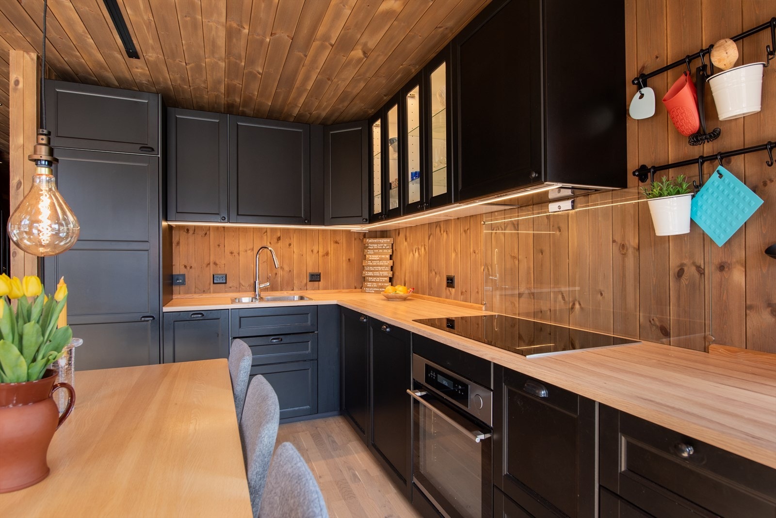 Kjøkken med sorte profilerte fronter og laminat benkeplate. God skap og skuffplass til oppbevaring. Kjøkkenet har mekanisk avtrekk. Galleribilde