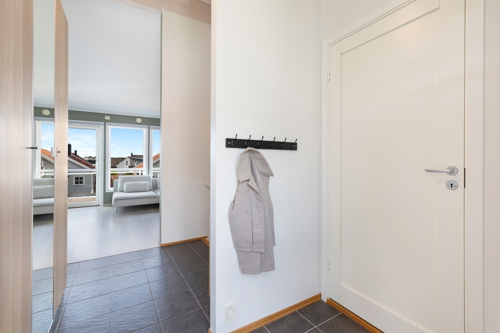 Boligen har flislagt entré med god plass til å henge av seg klær. Galleribilde