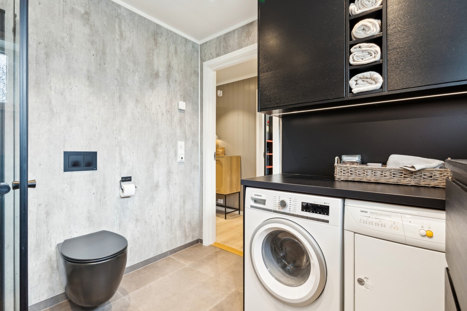 Veggene har baderomsplater, taket har himlingsplater med spotter og gulvet er flislagt. Galleribilde