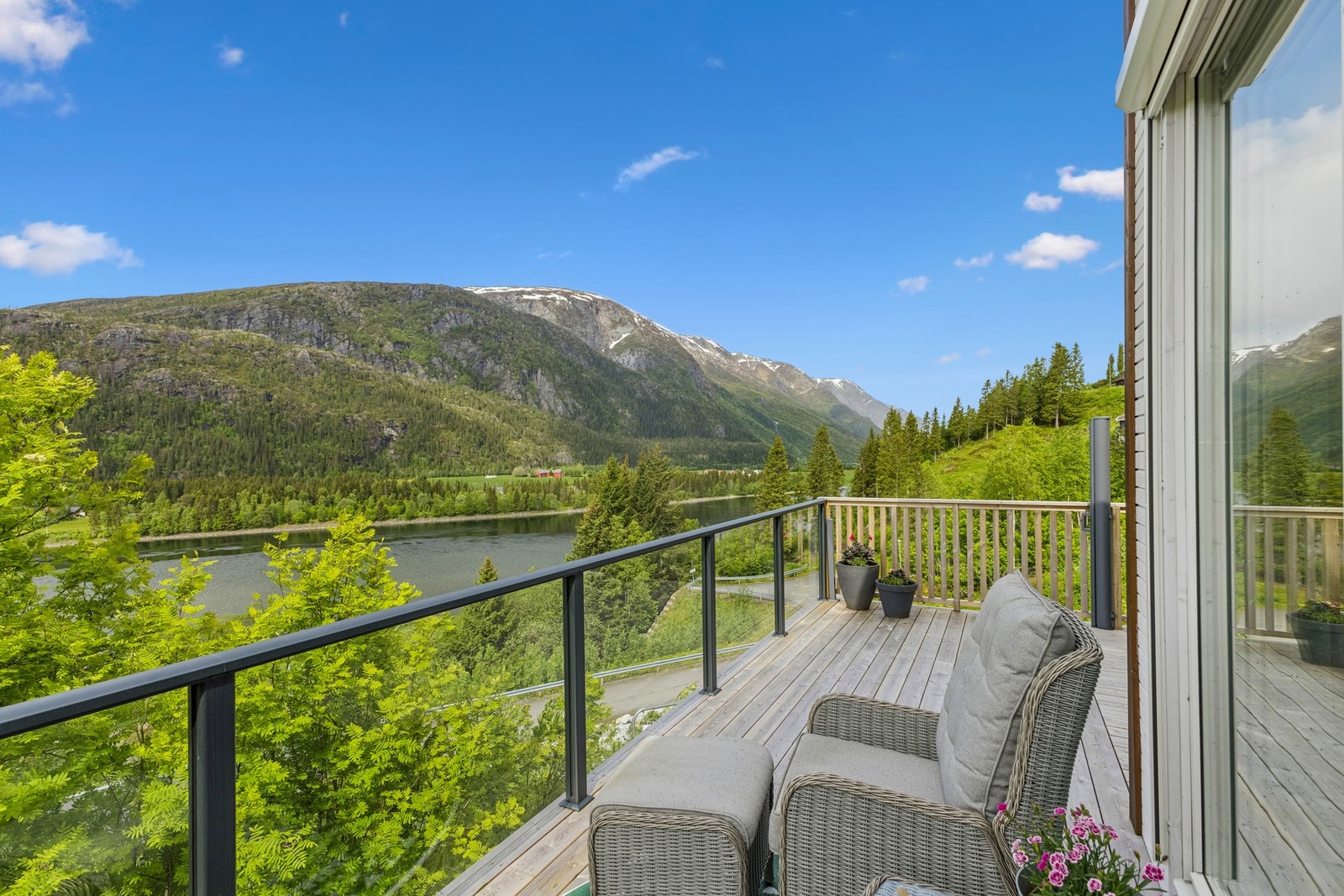 Uteplassen med utgang fra stuen byr på en suveren utsikt mot Vefsna og fjellet. Galleribilde