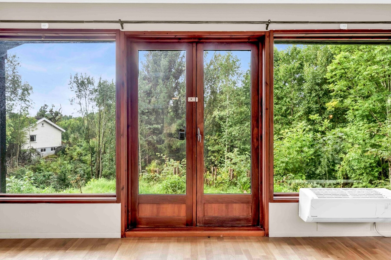 Fra stuen har man utgang til terrassen og store vindusflater sørger for utsikt over grøntarealene i hele rommet Galleribilde