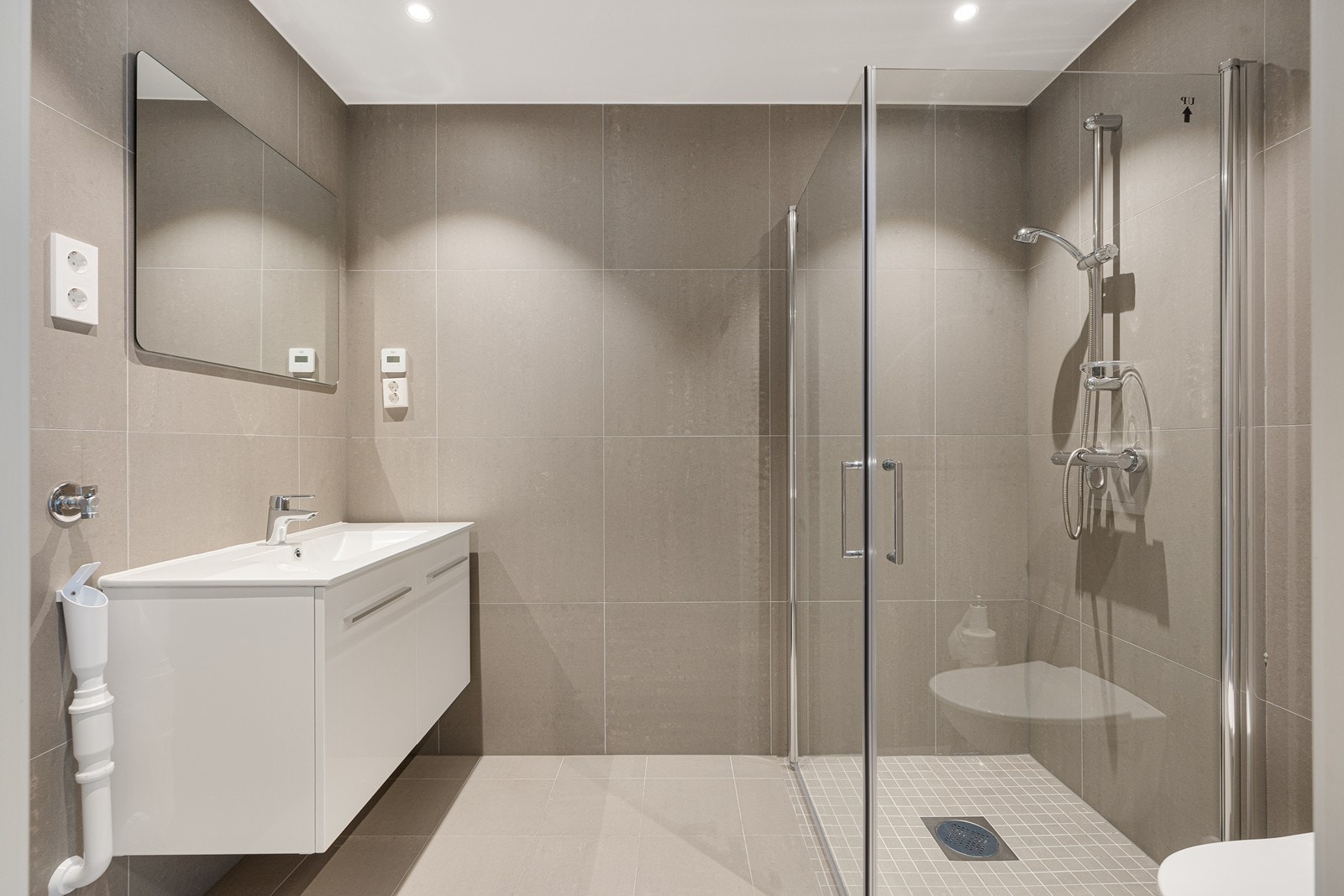 Det helflisede badet er holdt i behagelige fargenyanser og har vannbåren varme i gulvet, som i resten av leiligheten. Galleribilde