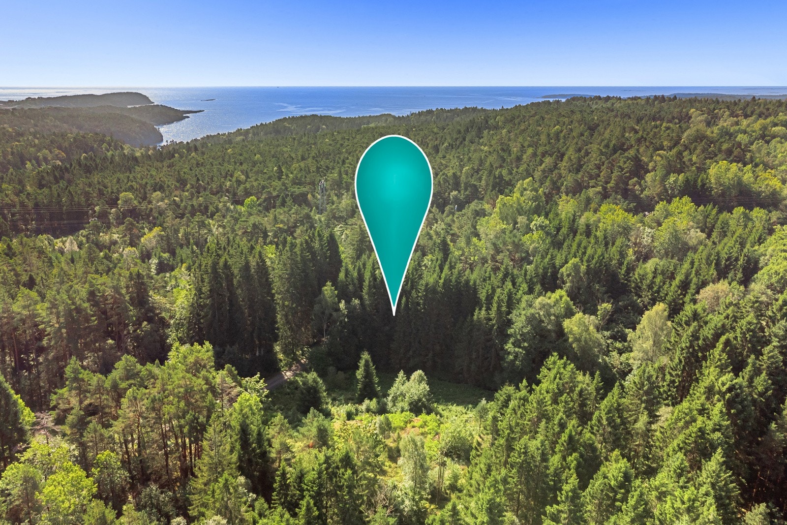 Tomten med kysten i bakgrunn. Det er ikke lange strekket på flotte stier før du er på utkikkspunkt som gir utsikt til kysten bl.a. Rognsfjorden og Jomfruland. Galleribilde