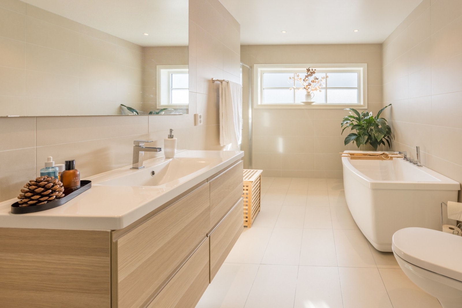 Delikat og romslig baderom med lyse flislagte vegger og gulv med gulvvarme. Galleribilde