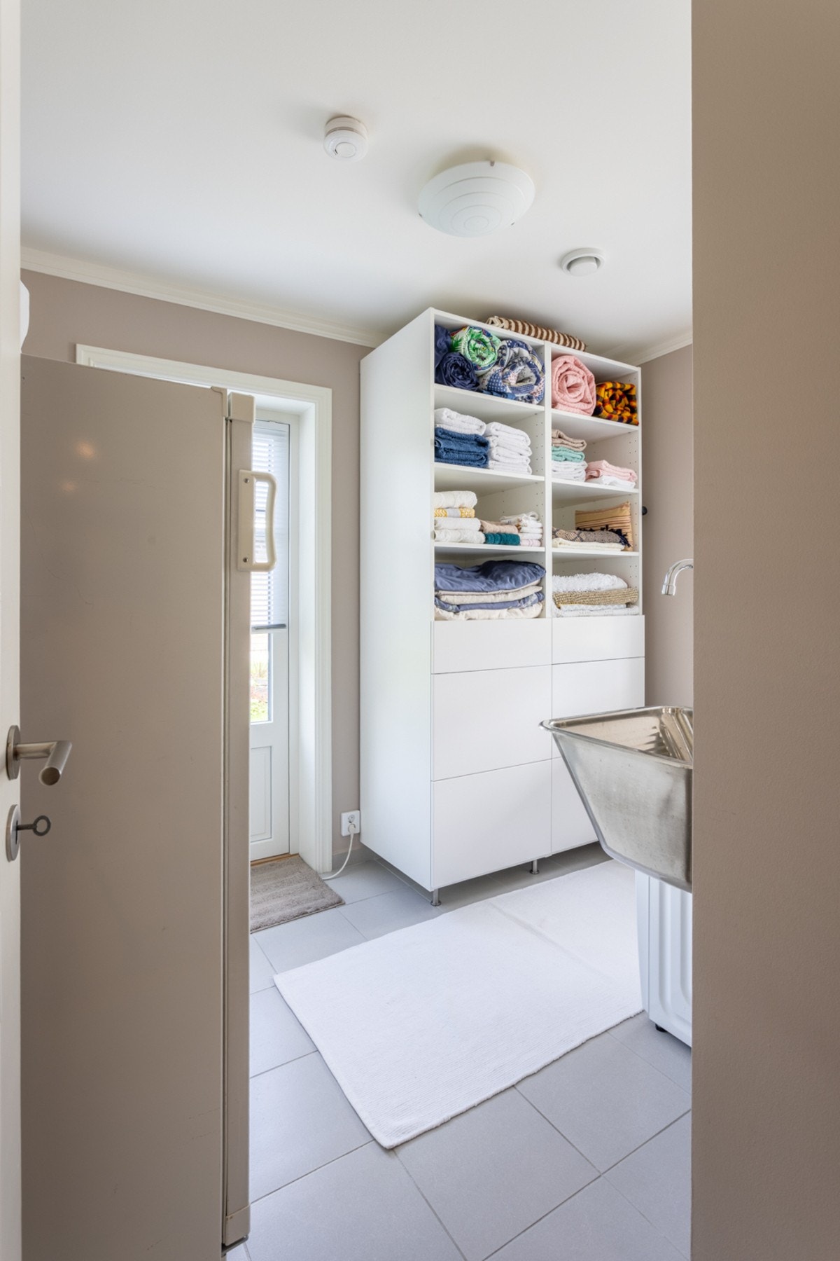 Skap til oppbevaring med brede skuffer og hyller for å bistå med ekstra plass til vaskemidler, sengetøy o.l. Galleribilde