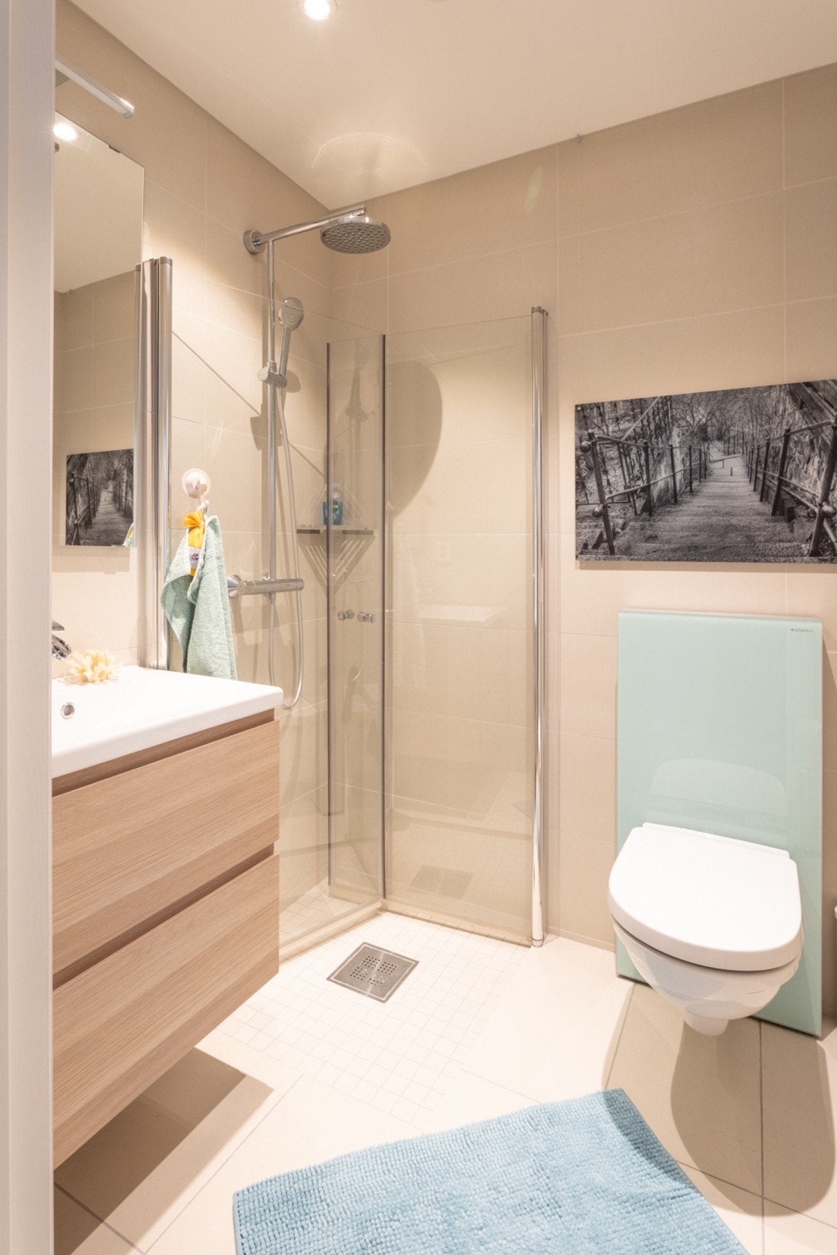 Fra gangen er det adkomst til et pent baderom bestående av vegghengt toalett, dusjhjørne, vegghengt servant og speil. Galleribilde