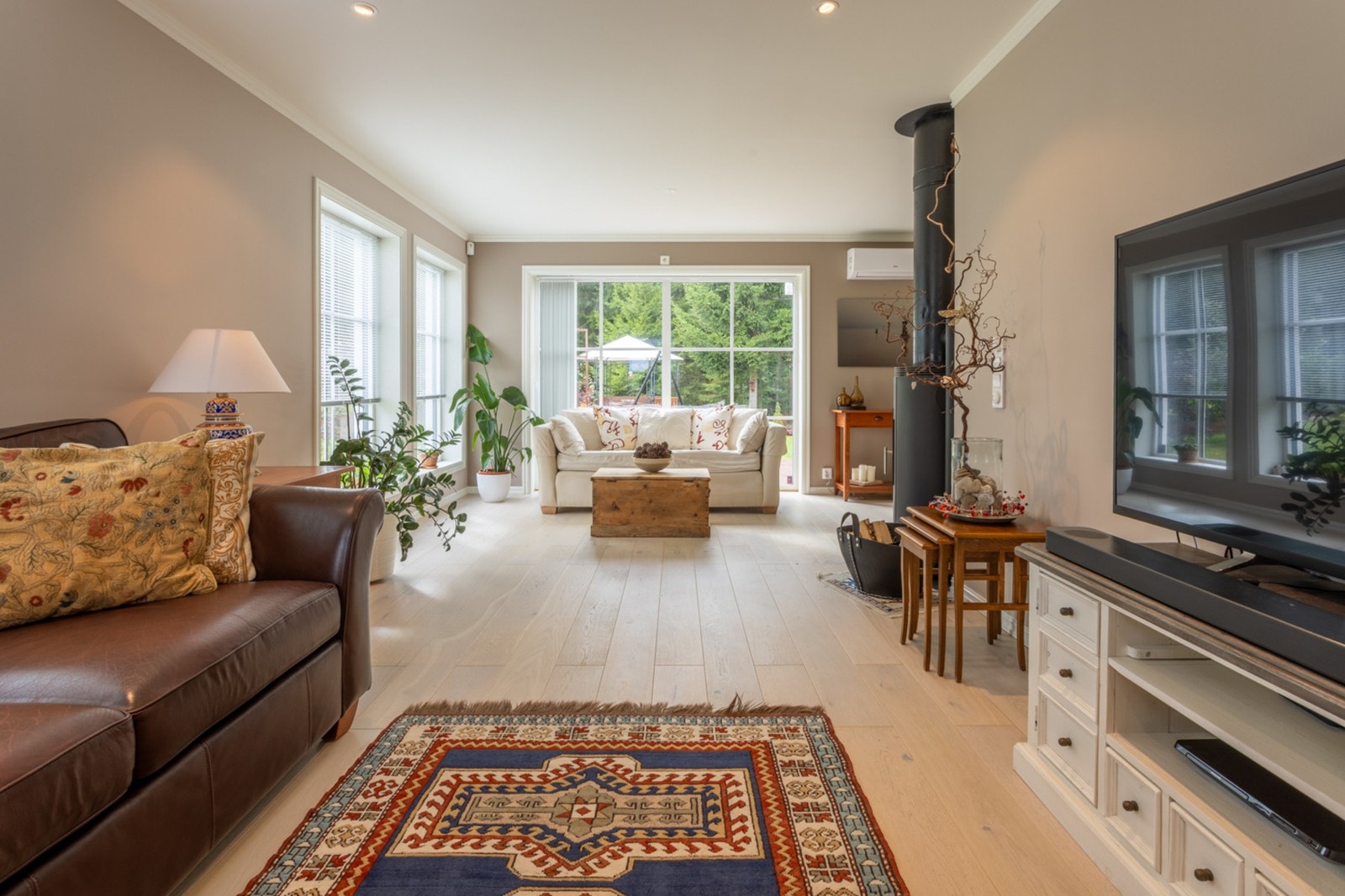 TV-stuen er møblert med Tv-møblement, sofa, lenestol, bord og belysning Galleribilde