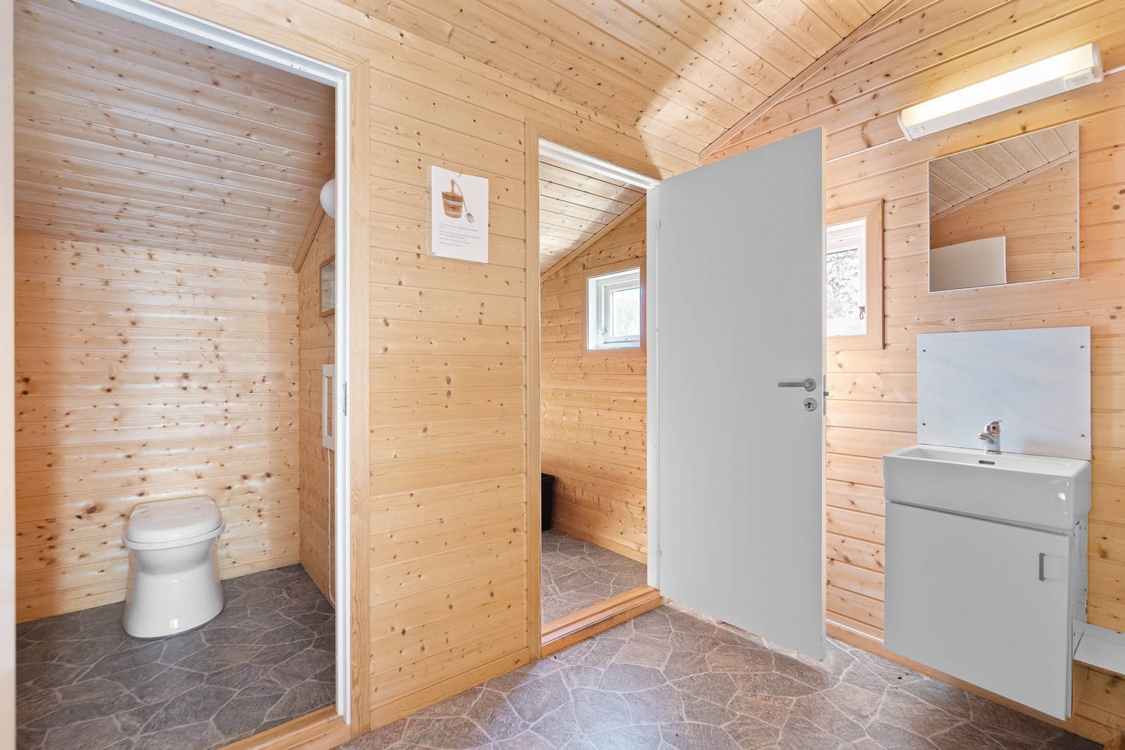 Uthuset inneholder to toalettrom. Galleribilde