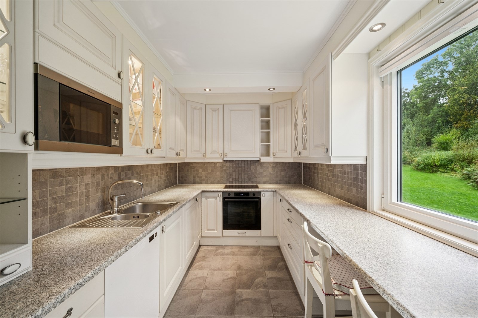 Lyst og tidløst kjøkken fra ca. 2008. Her har en alt en måtte trenge av skap-, skuff- og benkeplass. Galleribilde