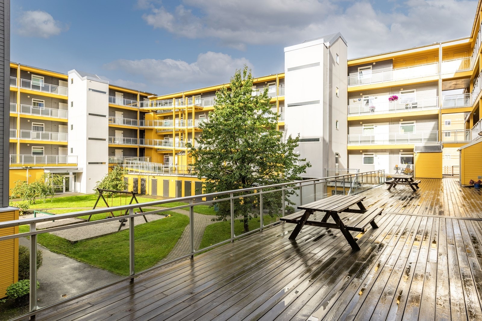 Hyggelig og skjermet felles atrium som er pent opparbeidet med gressplen og beplantninger, lekeapparater og fine sittegrupper. Galleribilde