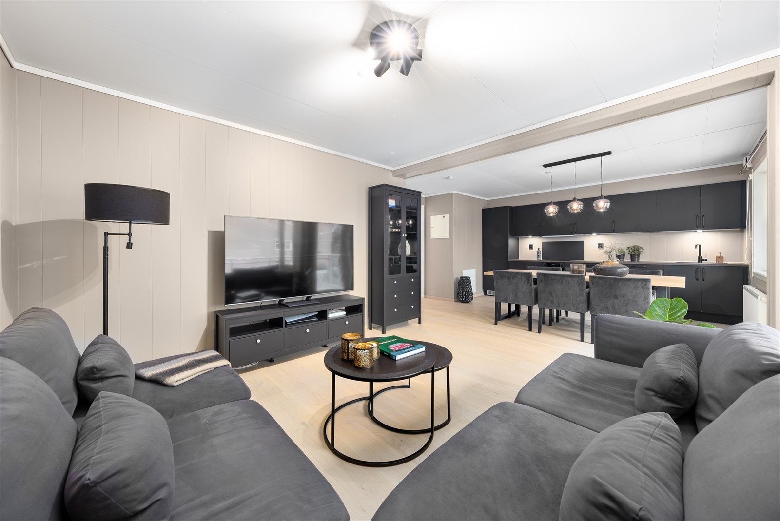 Den åpne planløsningen gir romslig plass til både sofagruppe og spisebord, og legger til rette for et sosialt og funksjonelt oppholdsrom. Galleribilde