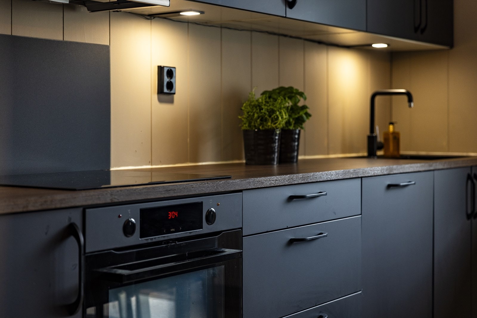 Under overskapene er det montert belysning som gir godt arbeidslys over benkeplaten og skaper en hyggelig stemning på kjøkkenet. Galleribilde