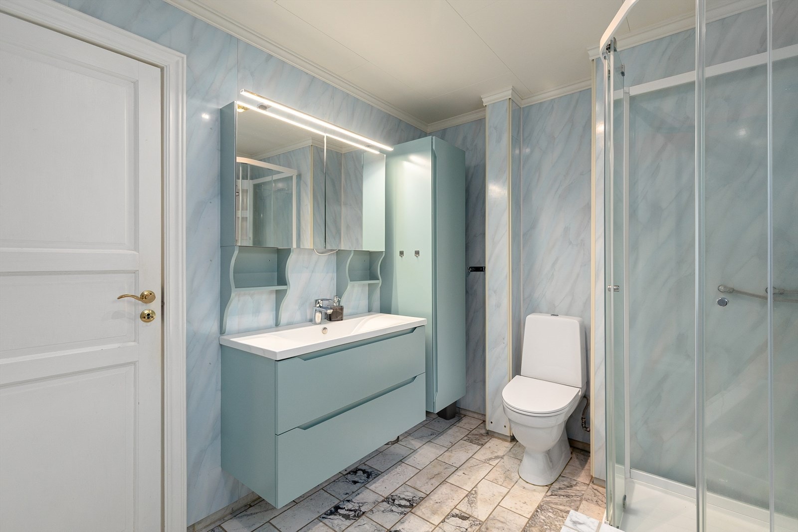 Badet er innreia med dusjkabinett, badekar, toalett, nedfelt servant, høgskap og speilskap. Galleribilde