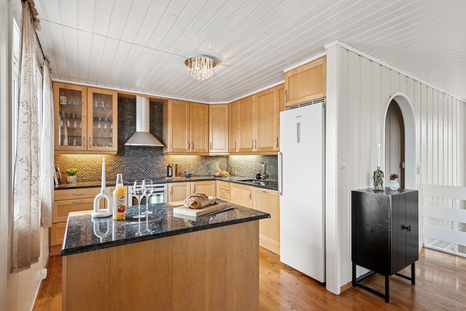 Innholdsrikt kjøkken med kjøkkenøy. Galleribilde