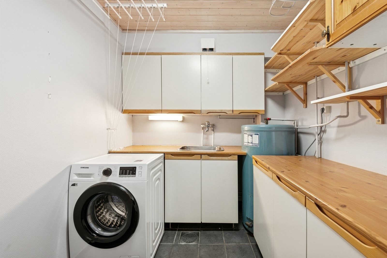 Praktisk med eget vaskerom med fliser på gulv og gulvvarme. Galleribilde