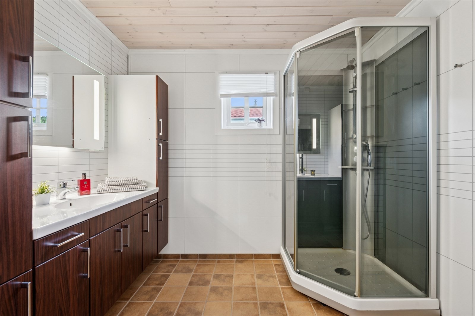 Flott baderom i hovedetasjen med fliser på gulv og gulvvarme, våtromsplater på vegg samt panel i himling. Galleribilde