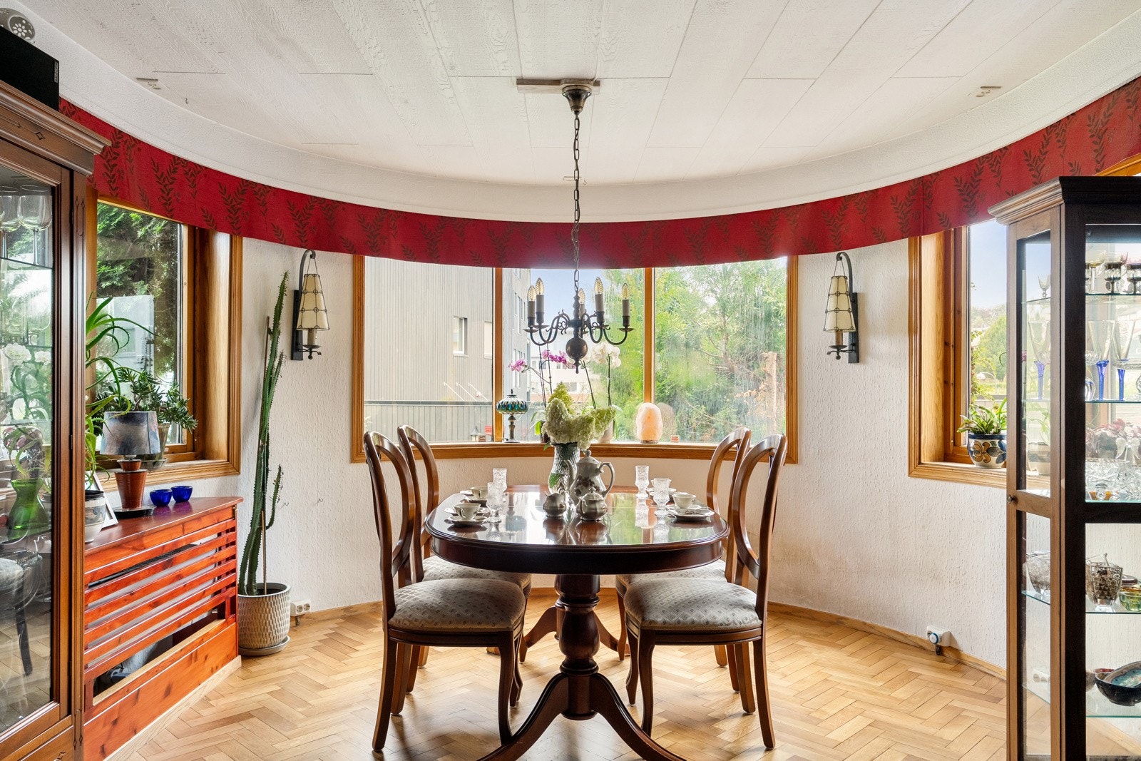 Tidstypisk bue med vinduer som slipper mye dagslys inn i stuen. Gulv i klassisk fiskebensparkett i eik, lyst og elegant. Galleribilde