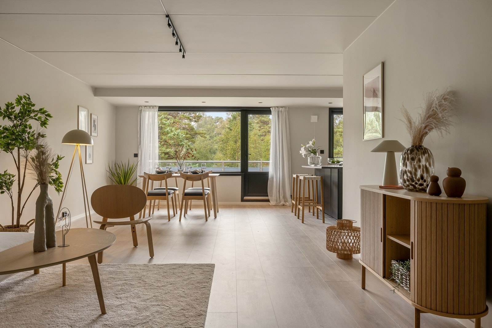 Stor stue med åpen kjøkkenløsning som har god plass til sofagruppe og spisebord Galleribilde