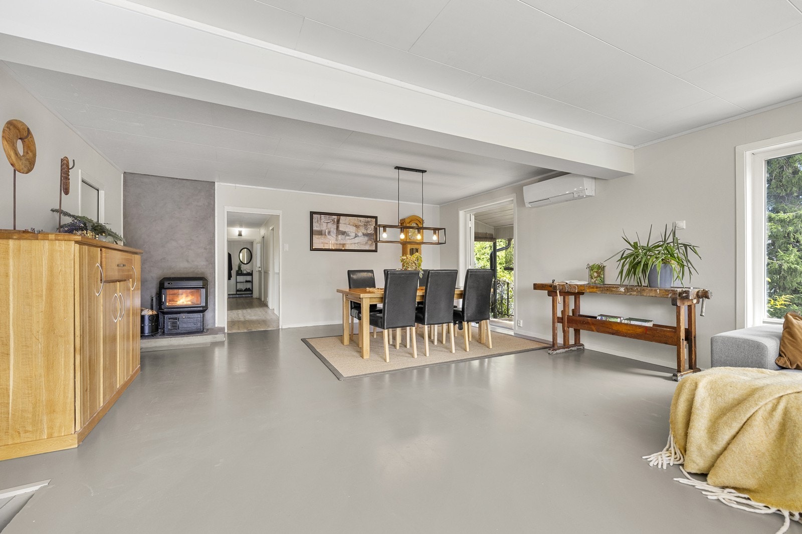 Vedovnen gir en lun atmosfære, supplert av en luft-til-luft varmepumpe fra 2016 for effektiv oppvarming. Galleribilde