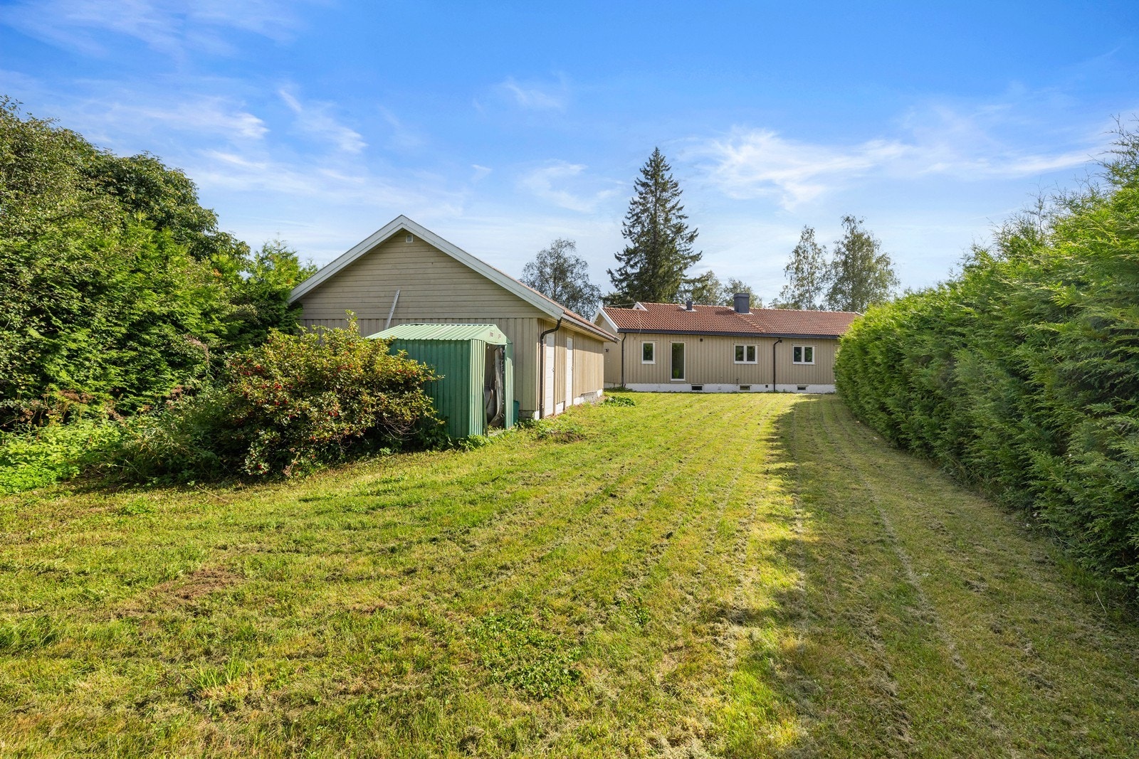 Den frittliggende garasjen på 64 m² har leddport med elektrisk åpner og god lagringsplass. Galleribilde