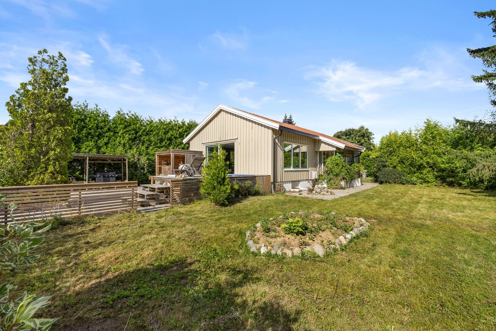 Den store tomten på 1216 m² er pent opparbeidet med plen og beplantning. Galleribilde