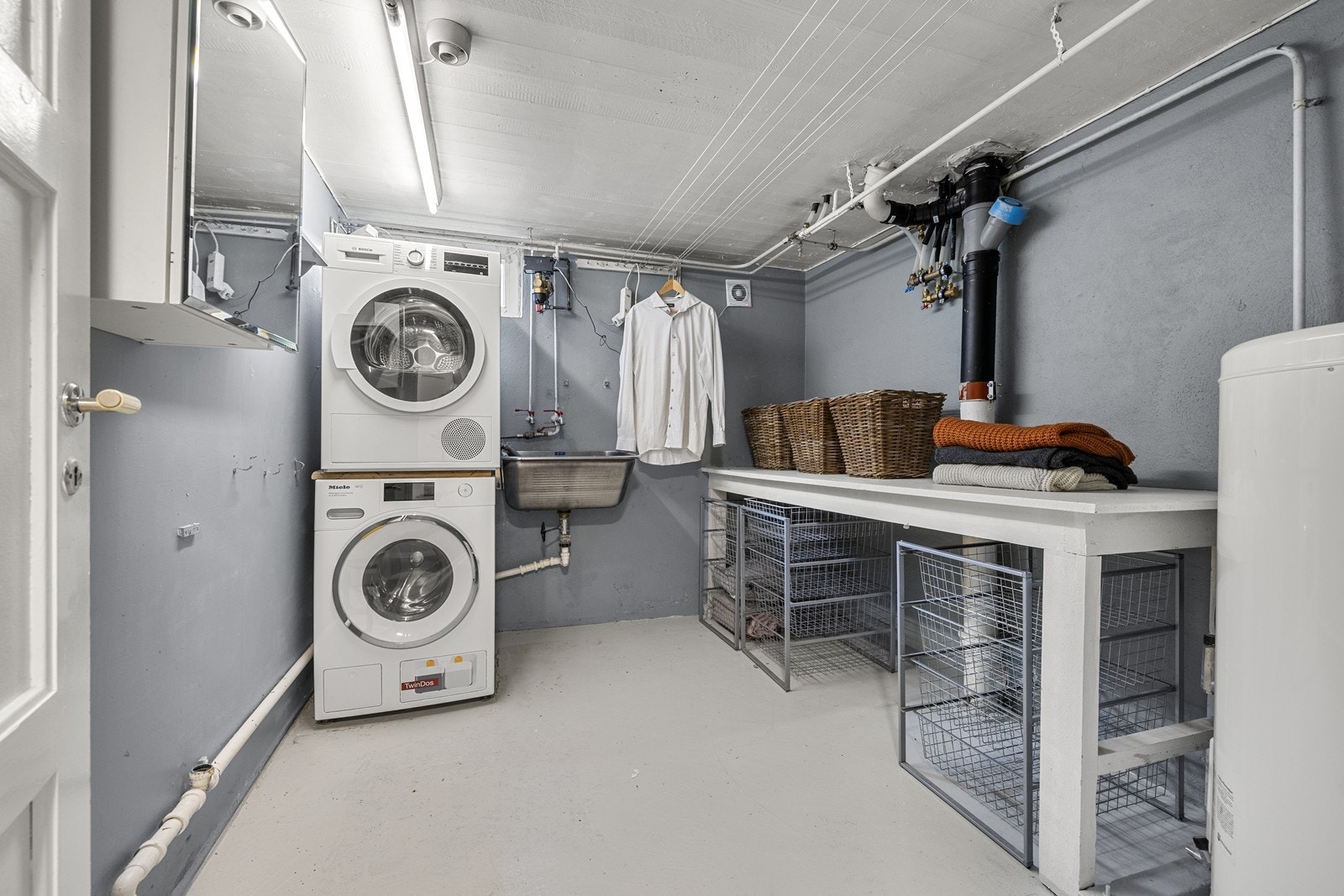 Vaskerommet er praktisk innredet med opplegg for vaskemaskin og en 194L varmtvannstank fra 2015. Galleribilde