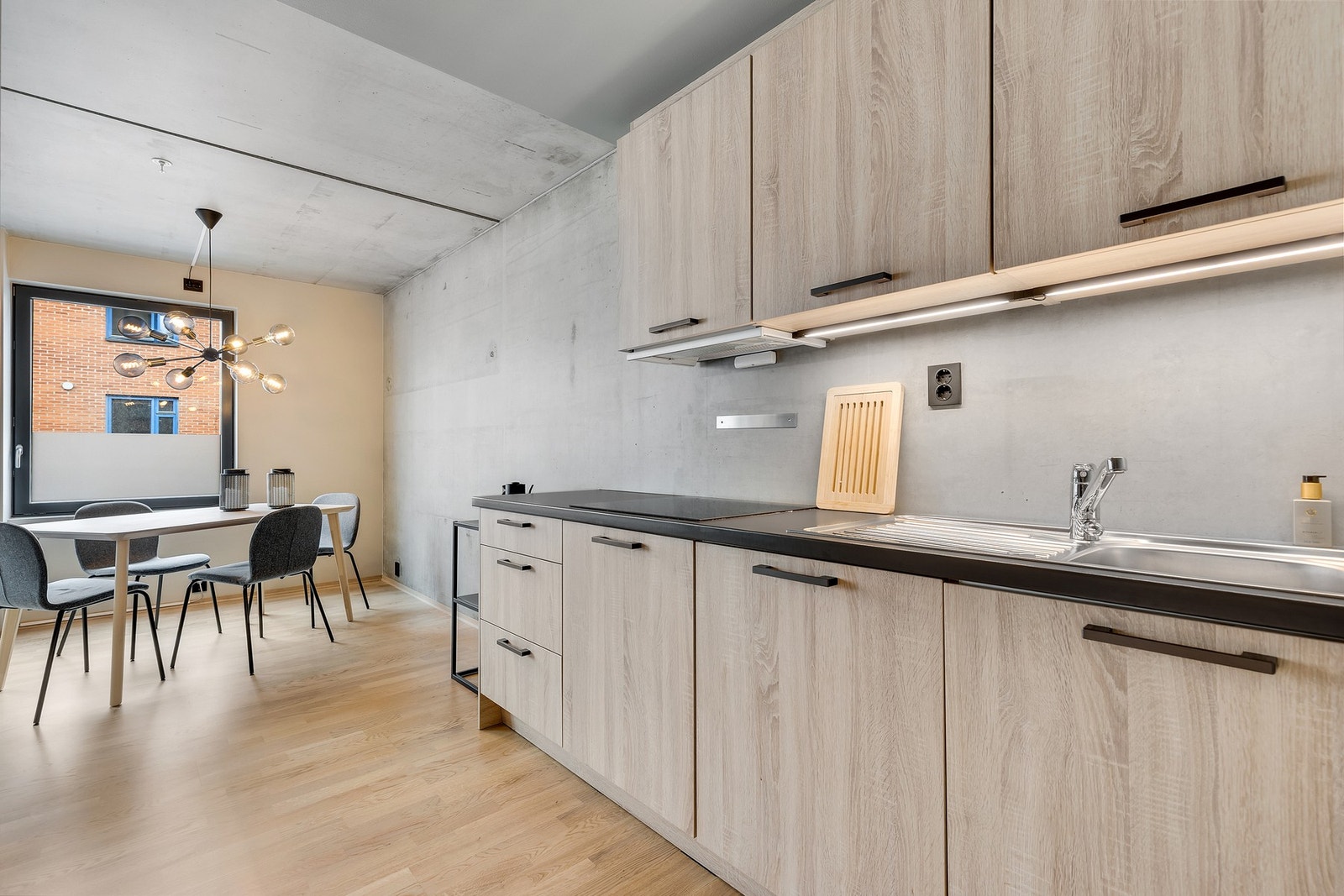 Svarte detaljer på kjøkkenhåndtak, skinner i tak, vinduskarmer, dørhåndtak og stikkontakter er gjennomgående i hele leiligheten og gir et gjennomført uttrykk. Galleribilde