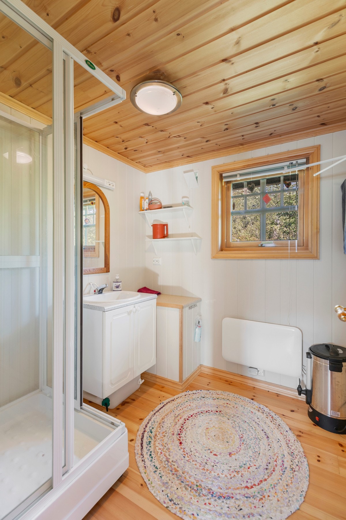 Badet har furubord på gulv og panel på vegger. Rommet er utstyrt med dusjkabinett og underskap med servant. Rommet er ikke bygget som våtrom og dusj benyttes med tilbåret vann og elektrisk pumpe. Galleribilde