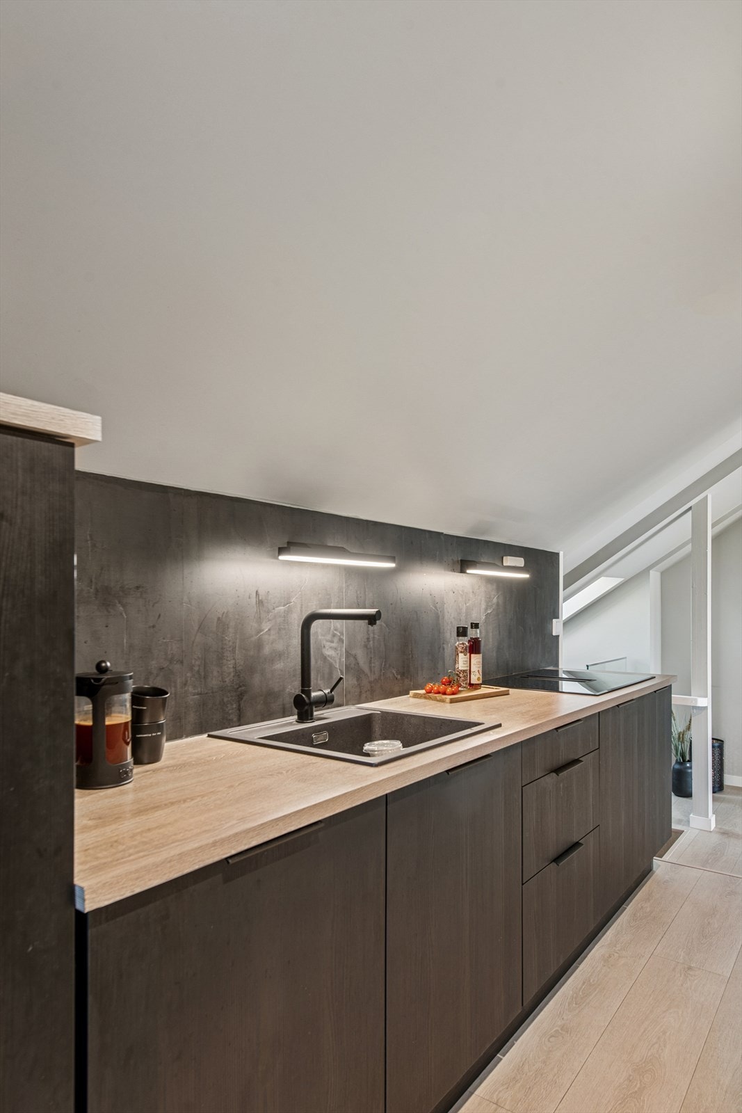 Kjøkkenet er levert av HTH og har slette fronter i mørk utførelse, laminert benkeplate og integrerte hvitevarer som koketopp med avtrekk, stekeovn, kjøleskap og oppvaskmaskin. Galleribilde