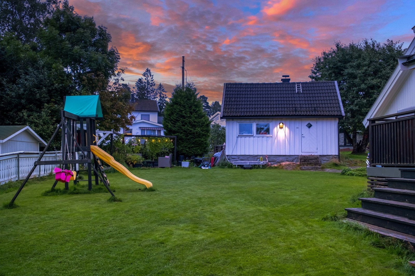 Det hvite bygget til høyre for lekestativet er en utendørs bod. Galleribilde