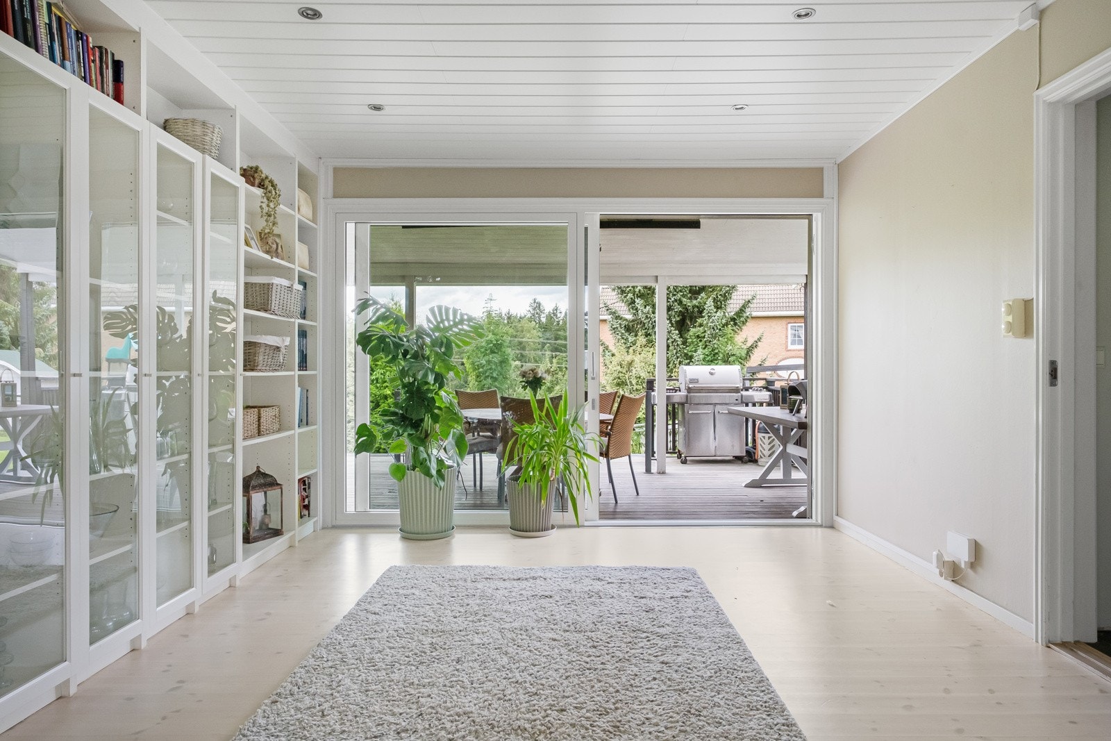 Det er et lyst rom med stor skyvedør ut til terrassen. Galleribilde