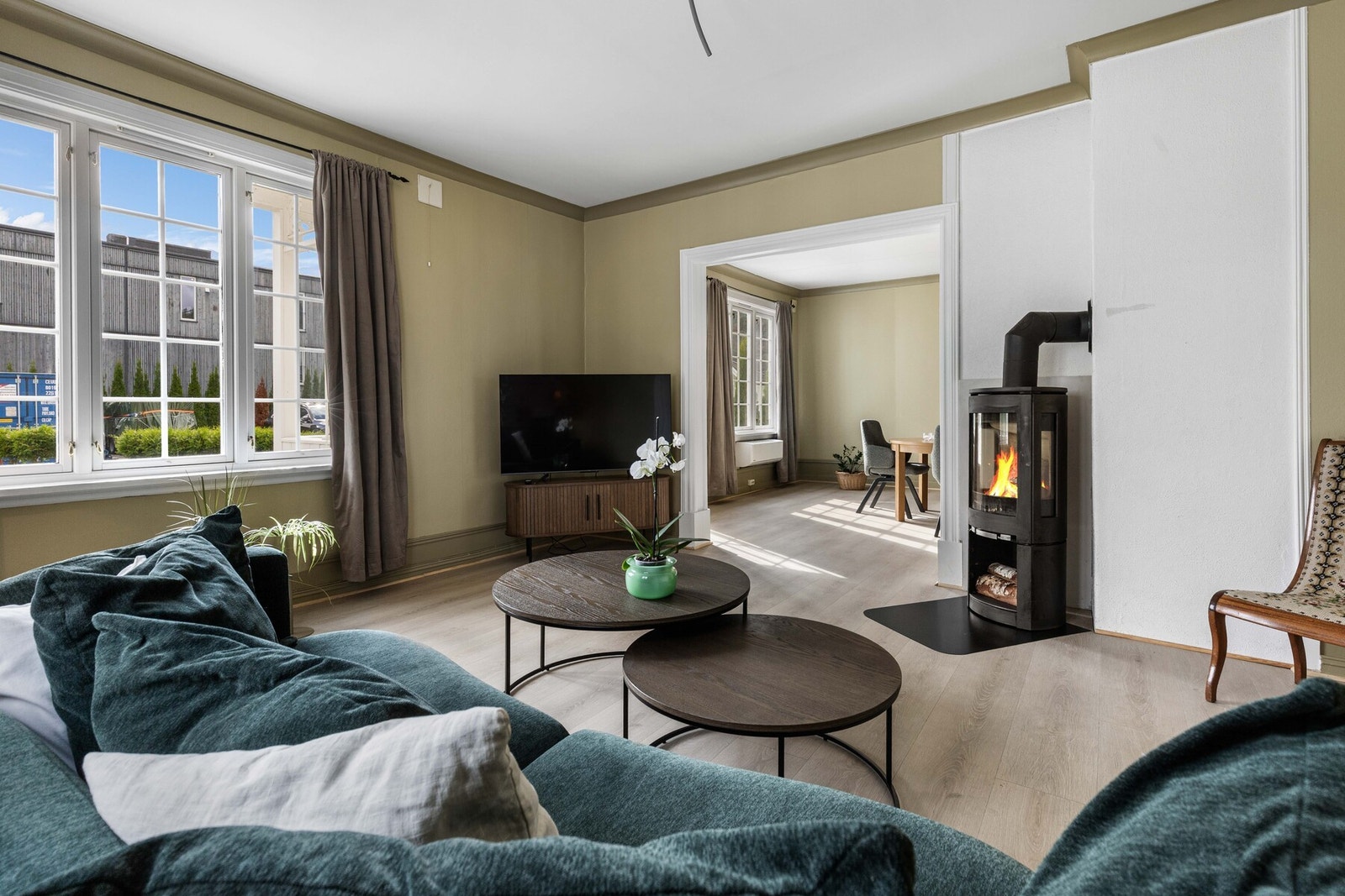 Romslig stue med peis, store vinduer og adskilt spisestue. Galleribilde