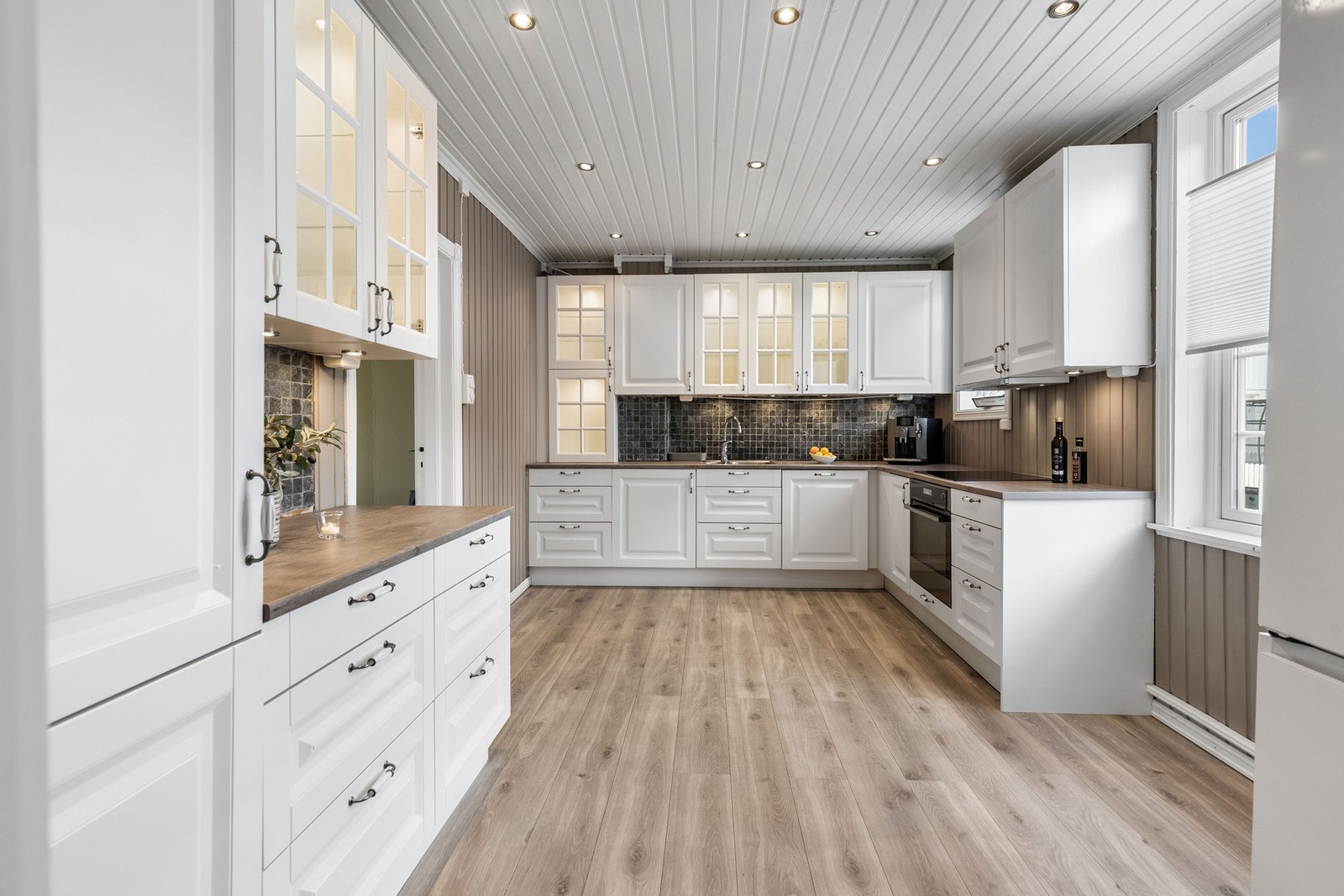 Moderne kjøkken med lyse fronter, integrerte hvitevarer og god benkeplass. Galleribilde