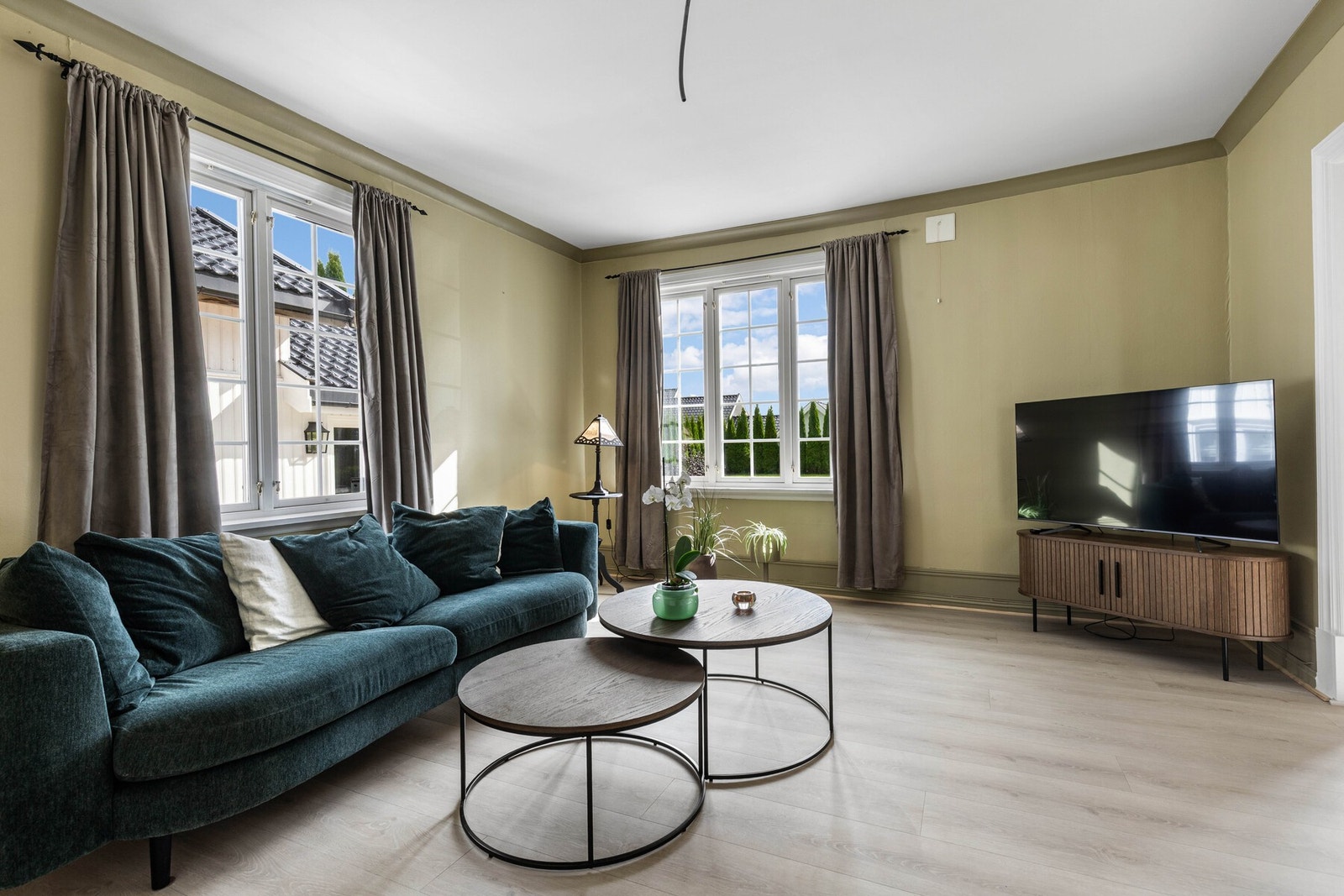 Stuen har lyse vegger, store vinduer og lyst gulv. Galleribilde