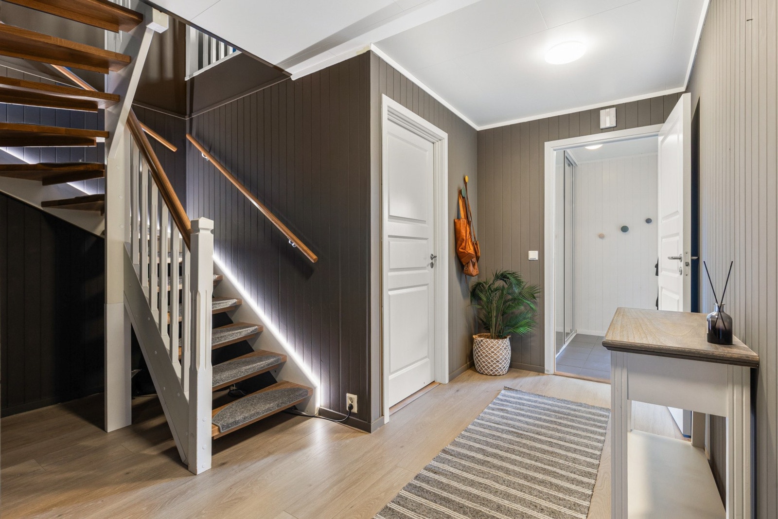 Videre tar vi oss inn til en mellomgang som fører oss til to av boligens soverom, baderom og et vaskerom Galleribilde