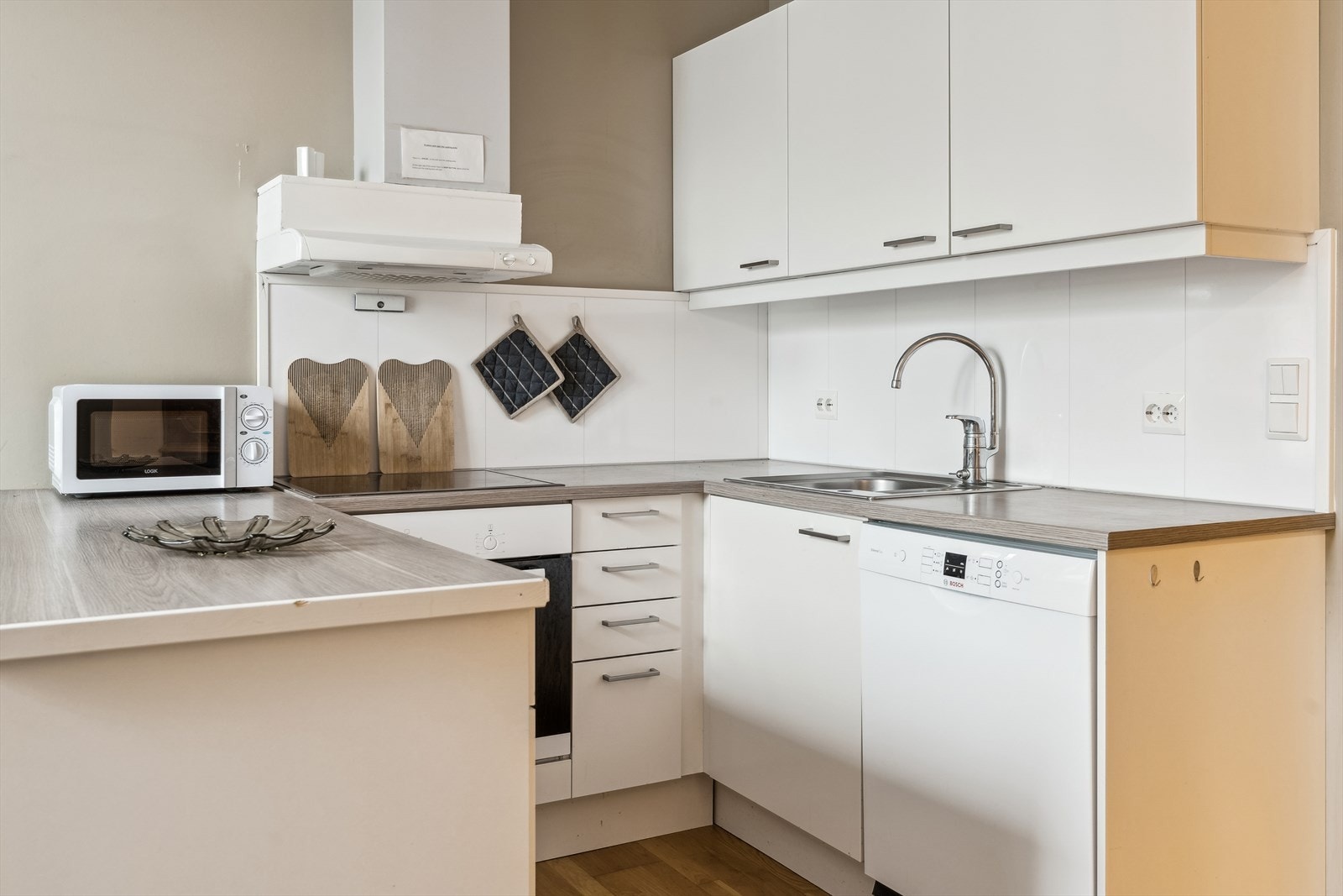 Kjøkkeninnreiing med kvite, glatte frontar og laminat benkeplate. Galleribilde