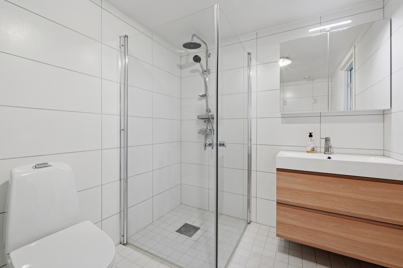 Pent flislagt baderom med varmekabler i gulvet. Det er mekanisk avtrekk. Galleribilde