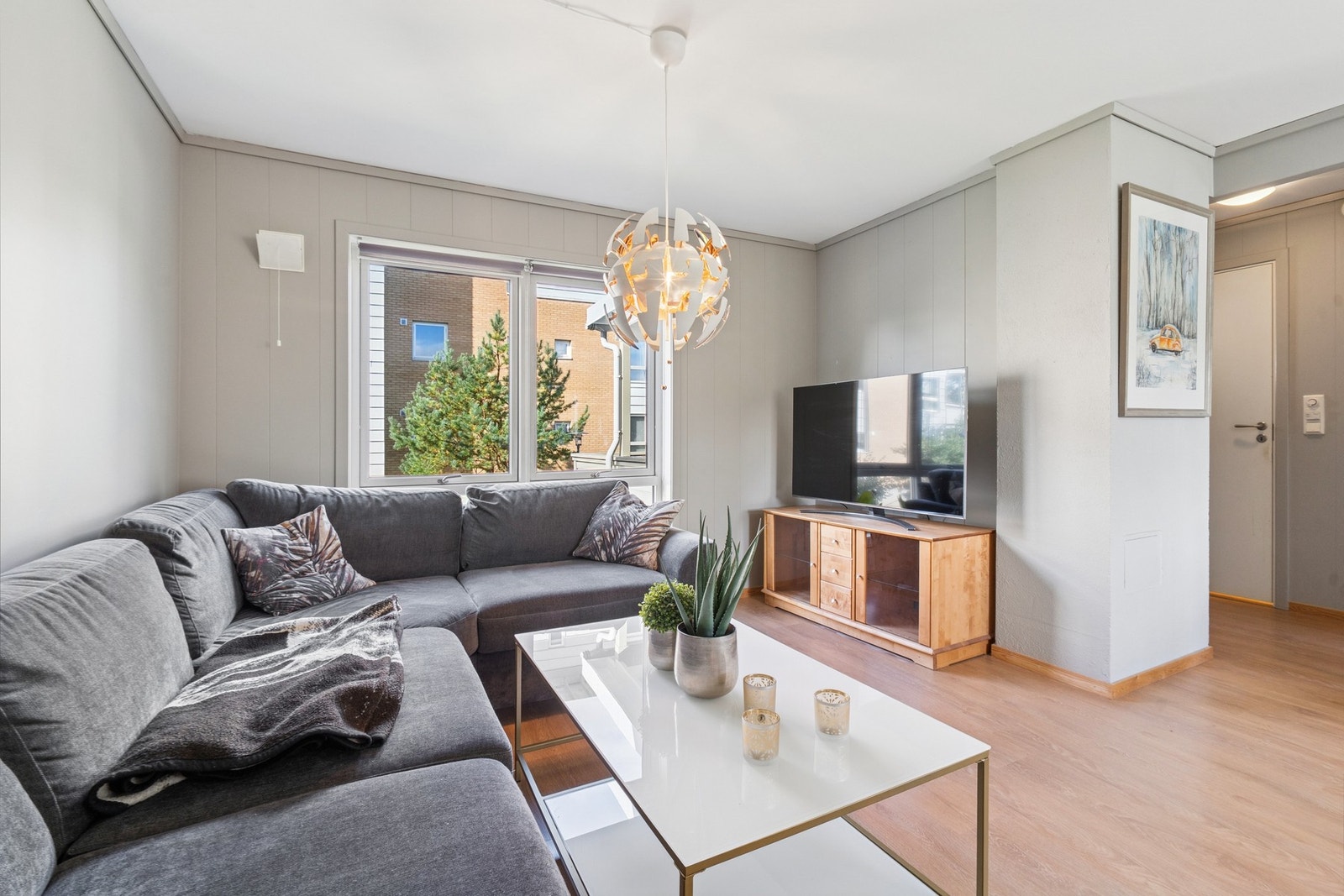 Hyggelig tv-stue med god plass til en stor sofa. Leiligheten har fine møbleringssoner. Galleribilde