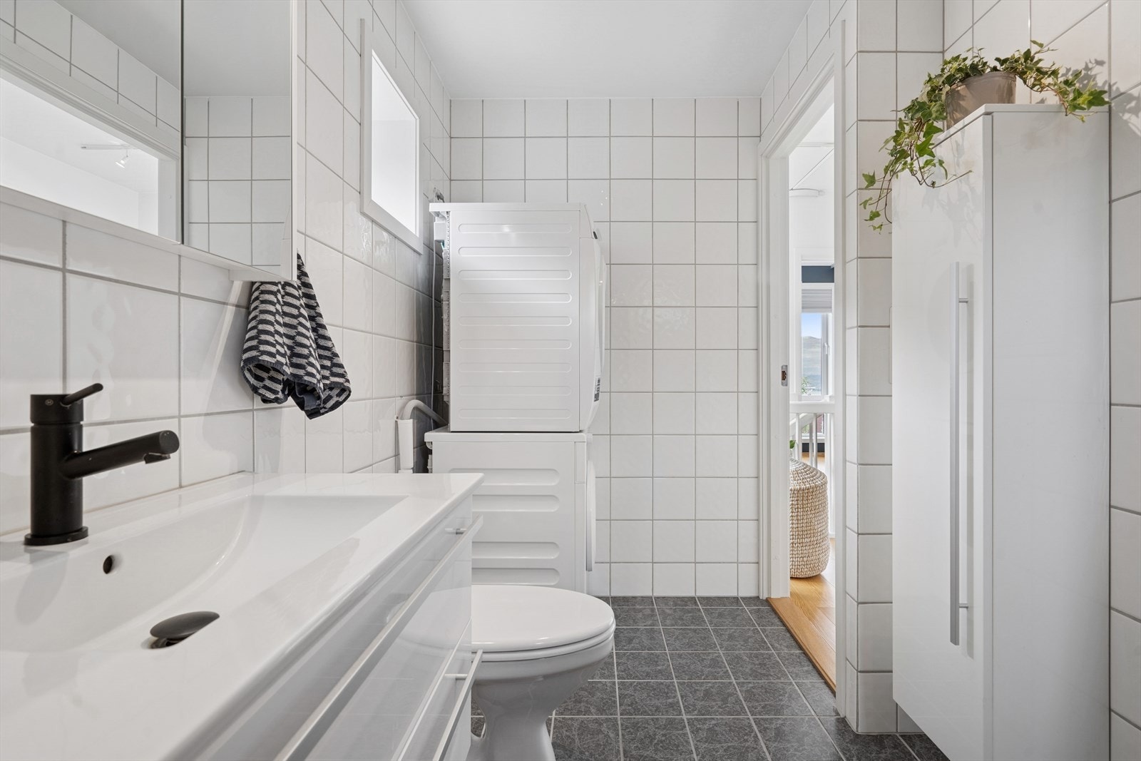 Badet er tidløst med fliser på både vegger og gulv. Det er elektriske varmekabler i gulvet. Galleribilde