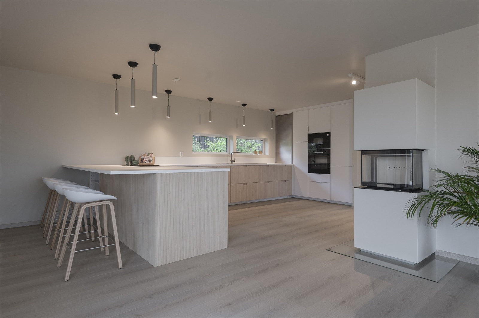 Stort og moderne kjøkken med åpen planløsning mot spisestue og stuedel. Galleribilde