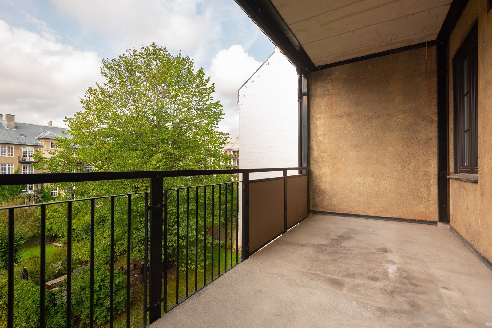 Stor balkong som forlenger stuen ut i det fri og gir flott utsyn over grønne og frodige bakhager Galleribilde