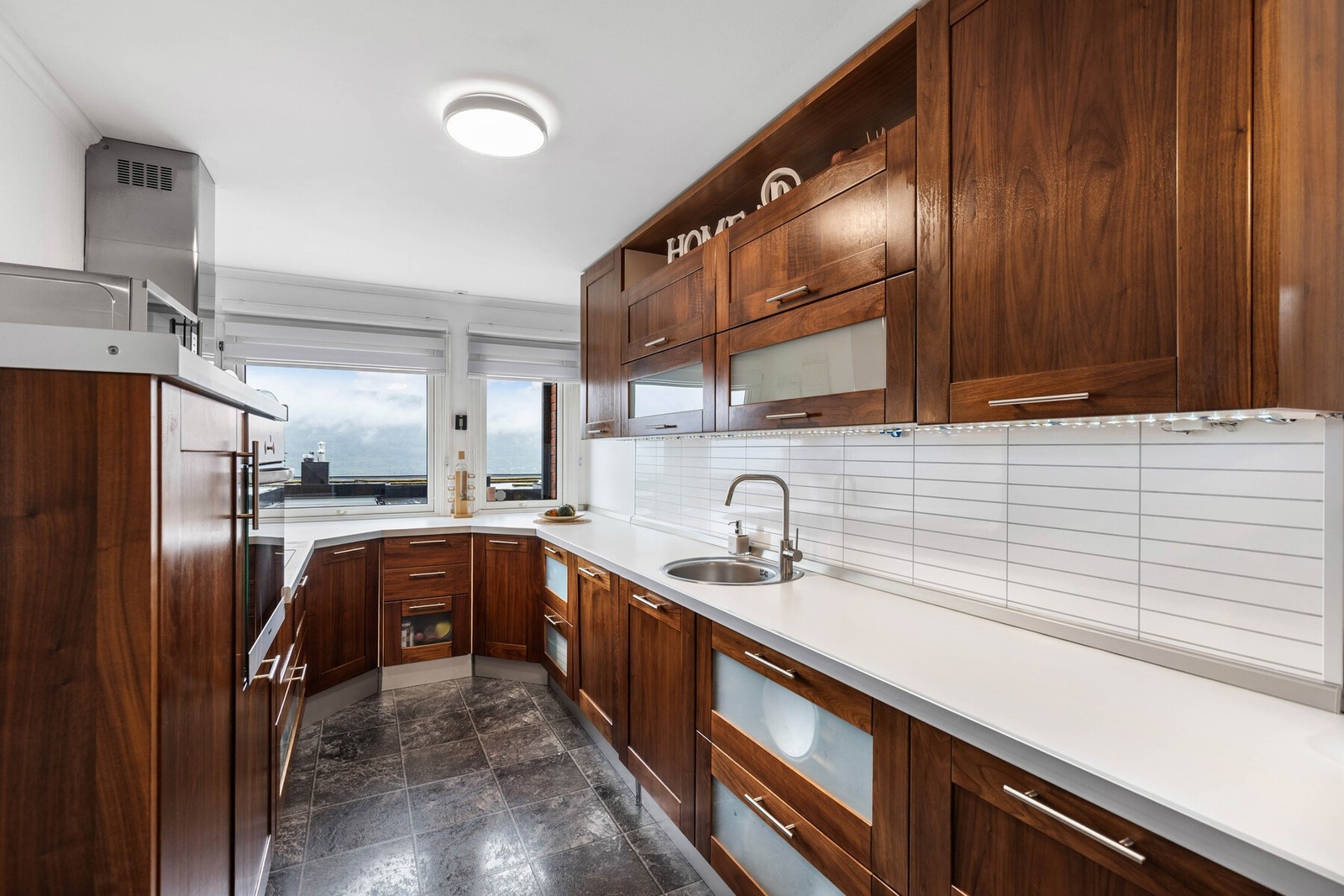 Pent kjøkken av heltre med integrerte hvitevarer. Galleribilde