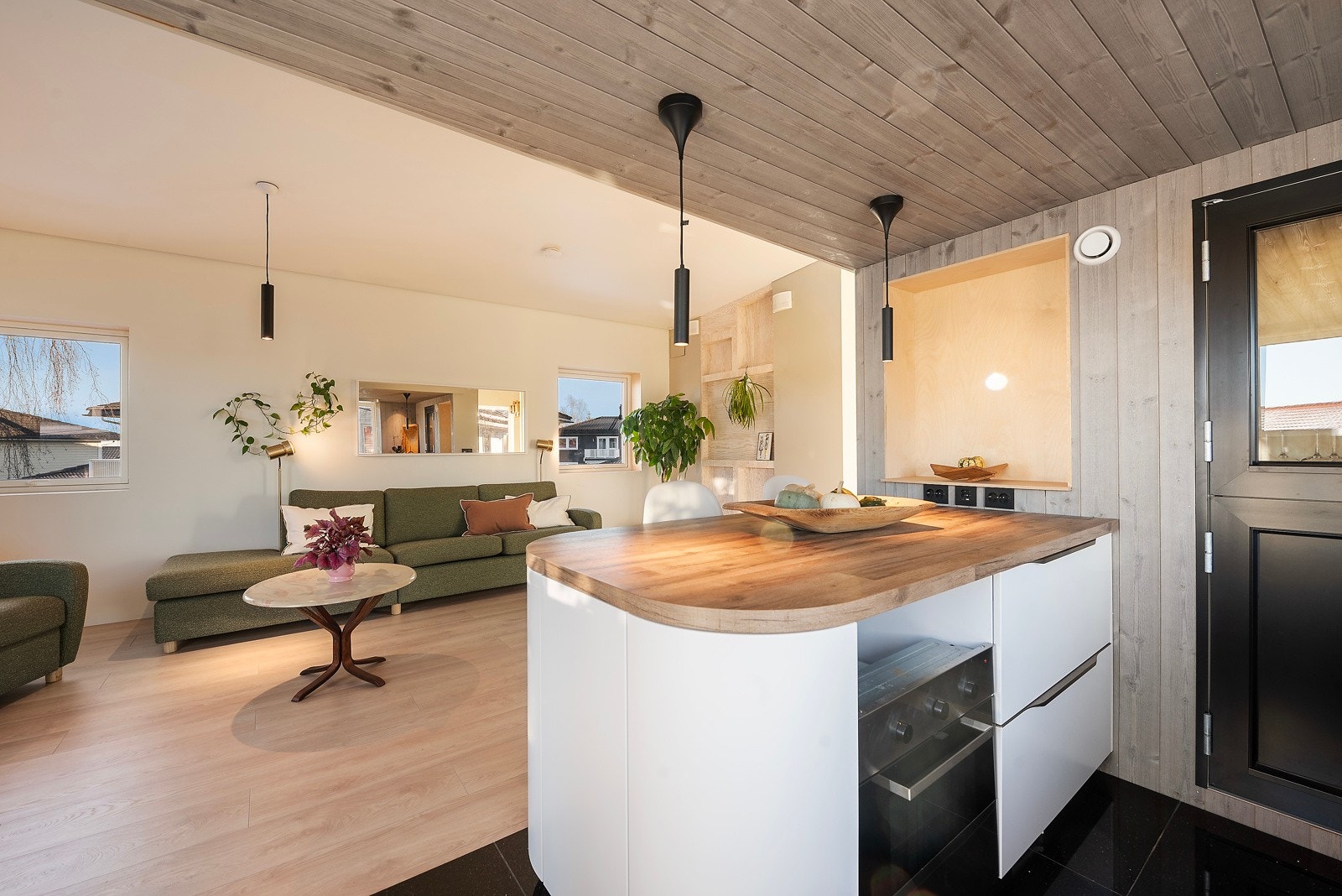 En lys stue/kjøkken med god takhøyde, som samtidig gir en varm og lun følelse Galleribilde