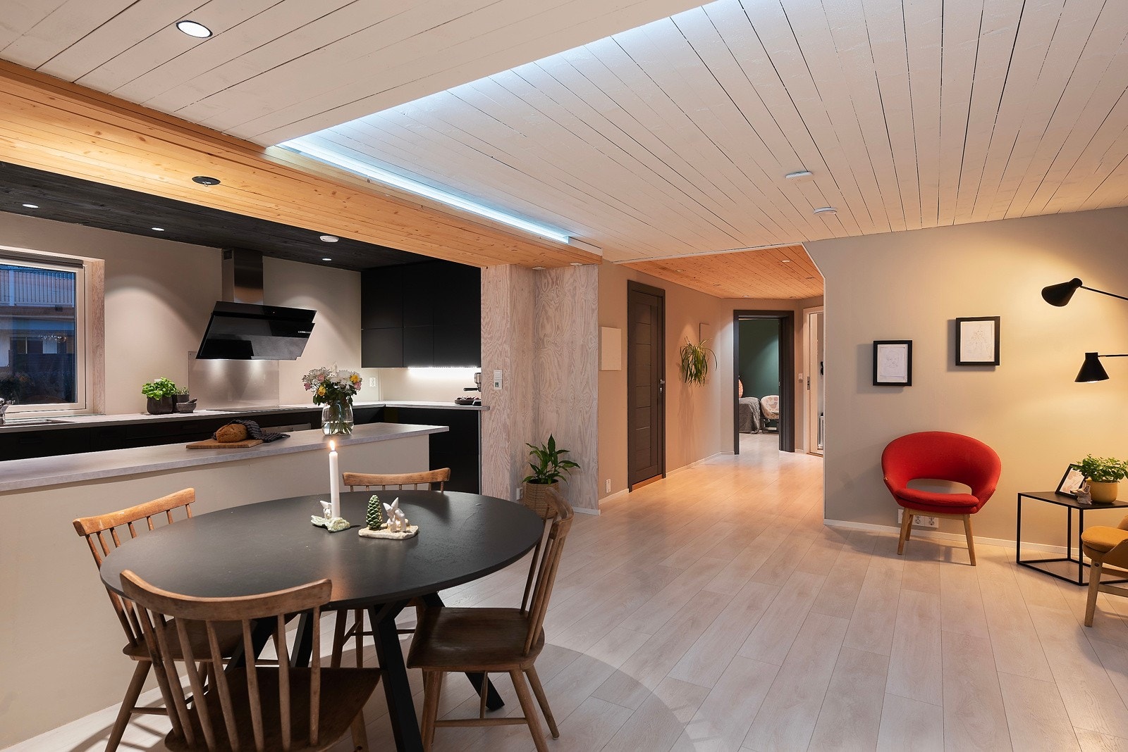 Her får du stue og kjøkken i en åpen løsning, med mørk innredning som harmonerer med det lyse åpne rommet. Downlights og store vindusflater lyser opp rommet og skaper en luftig atmosfære Galleribilde